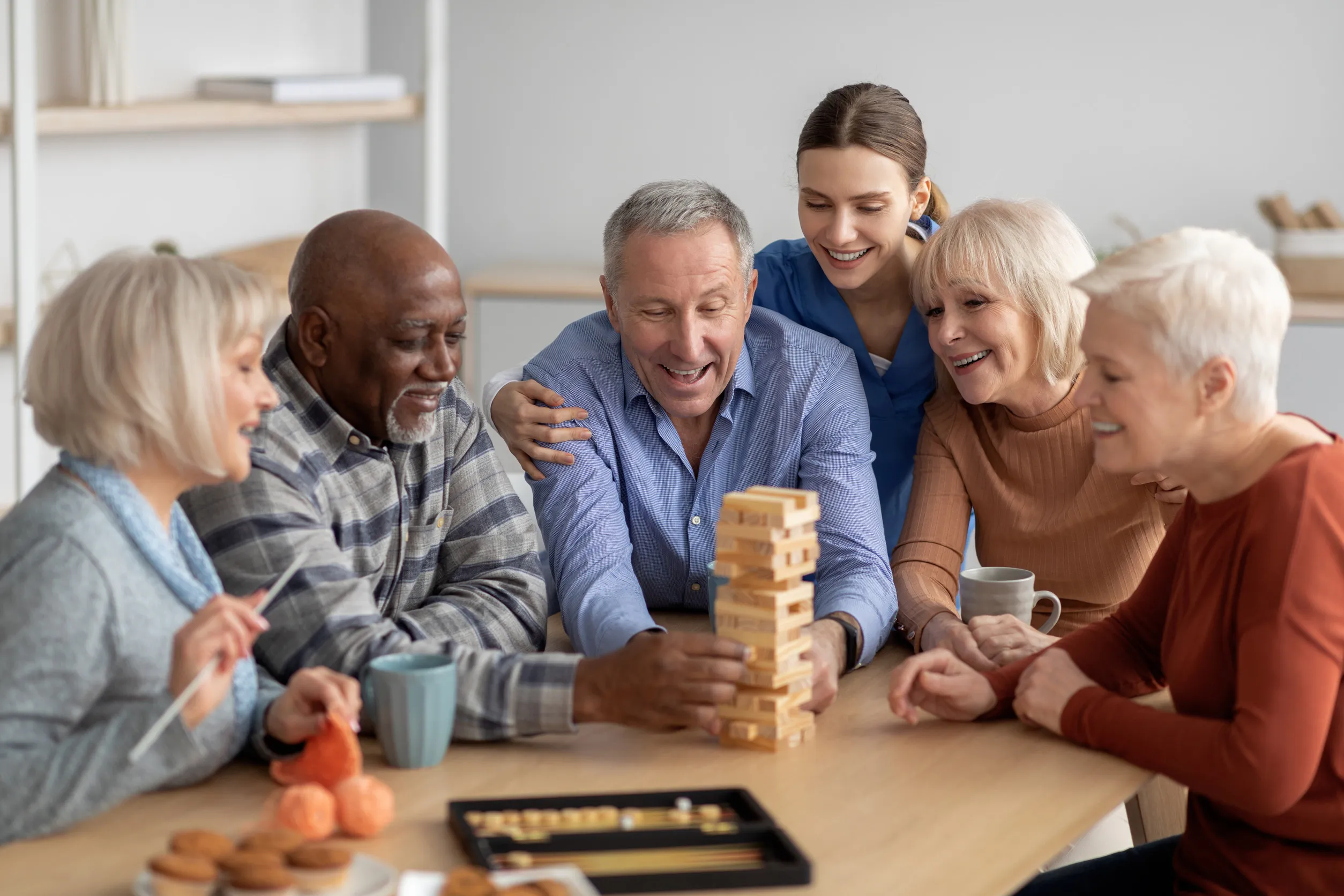 Cheerful multiracial senior people playing jenga at sanatorium